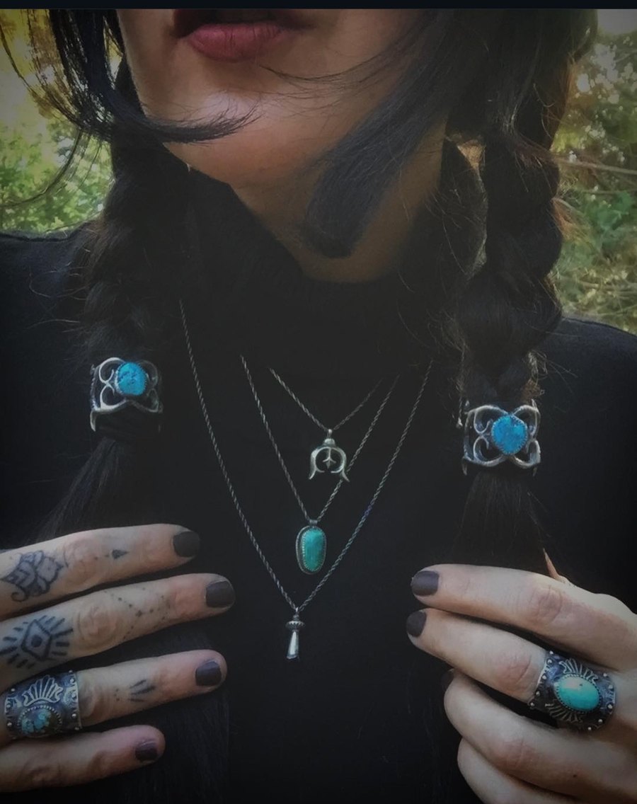 Jenna Knight wearing her turquoise and silver hair bindings in two braids, layered squash blossom necklaces and her own rings